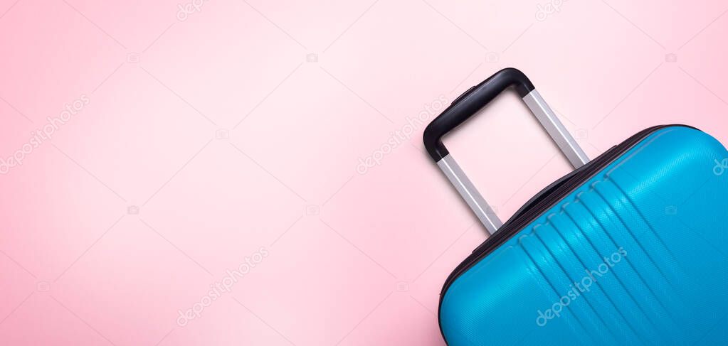 Blue suitcase on pastel pink background Summer holidays, vacation, travel concept Banner Minimal Copy space