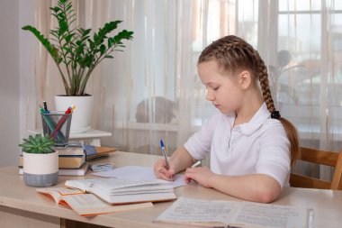Liseli kız evde ders çalışıyor. Uzaktan eğitim, evde eğitim. Kişisel izolasyon kavramı - Resim