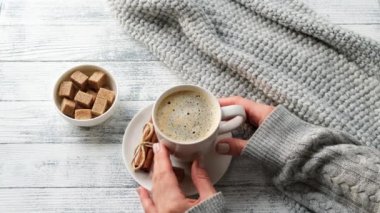 Fincanı kahve ile tutan kadın elleri. Sıcak sonbahar kompozisyonu. Hygge konsepti. 4K görüntü