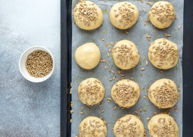 Tavaya tohum serpiştirilmiş çiğ hamur topları. Ev yapımı çörekler. Üst Görünüm - Resim