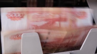 Para sayma makinesinde 5000 rublelik banknotları sayarken çekilen video görüntüsü, yakın plan. 4K görüntü
