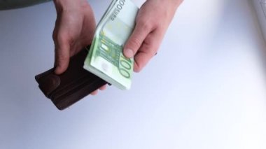 Avro banknotlarını sayıp cüzdana koyan bir adam. Finans ve iş konsepti. Seçici odaklanma. Yakın plan. 4K görüntü