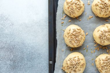Tavaya tohum serpiştirilmiş çiğ hamur topları. Ev yapımı çörekler. Üst Görünüm - Resim