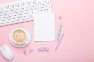 Pembe arka planda bir fincan kahve ve pastel renkli kırtasiye aksesuarları olan kadın işyeri. Üst Görünüm - Resim