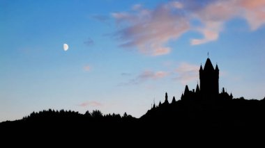 ay ışığında Oberwesel, Almanya tarafından aydınlatılmış bir tepenin üst kısmında korkunç bir kale silüeti                          