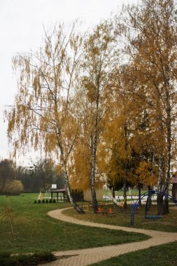 Küçük eğri yol önde gelen çocuk oyun Park alanı doğru sarı yaprakları ile kaplı