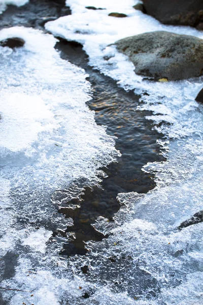 Parches de hielo cubren un pequeño arroyo y se aferran a las rocas en el Parque Nacional Tongariro, Nueva Zelanda — Foto de Stock