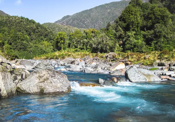 The Toaroha River radiating a deep blue/aqua color on a sunny day on the south island of New Zealand — Stock Photo, Image