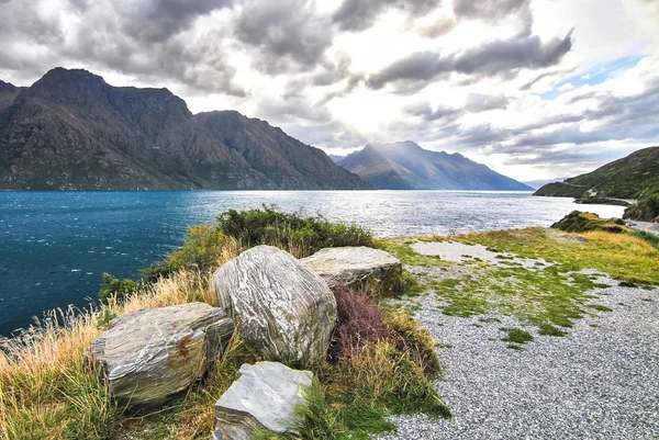 Dramatic lighting and tall mountains at Lake Wakatipu on New Zealand\'s south island