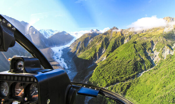 View from the cockpit of a helicopter as it flies over the Fox Glacier on New Zealand's south island