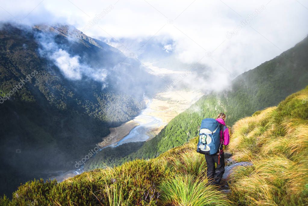 A hiker walks along a trail in the Matukituki Valley in Mt. Aspiring National Park, New Zealand