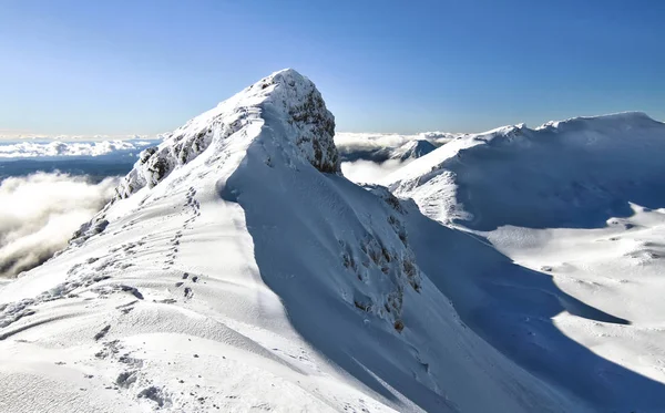 足跡をニュージーランドのルアペフ山の狭い山頂の尾根に沿ってリードします。 — ストック写真