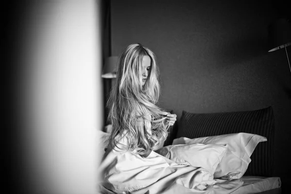 blonde girl lies in bed in the morning