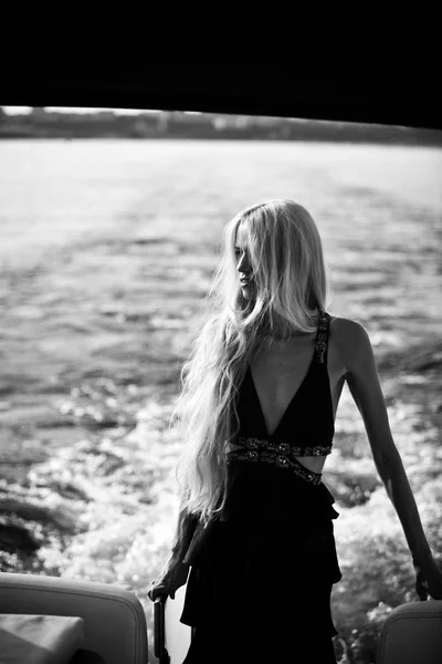 ヨットの浮かぶ黒の長いドレスで金髪 — ストック写真
