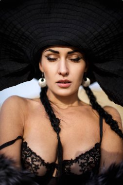 Kız şapka ve sutyen ile sahilde