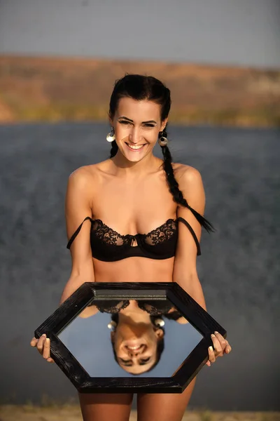 Kız sahilde ayna ile güneşlenme