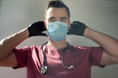 Coronavirus in the world. New coronavirus (2019-2020), a man in a blue medical face mask. The concept of quarantine of coronaviruses. clipart