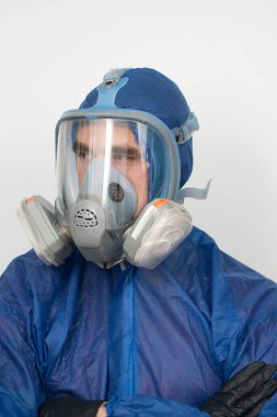 Koruyucu giysiler ve maske takmış bir adamın portresi.