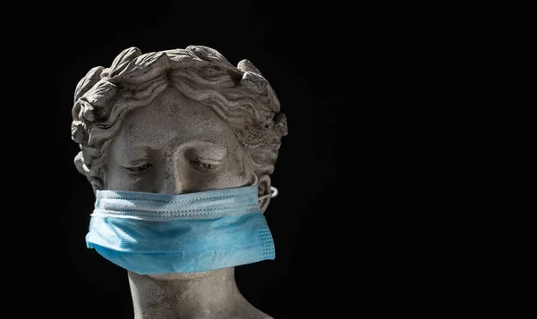 Siyah arka planda koruyucu mavi maskeli İtalyan heykeli