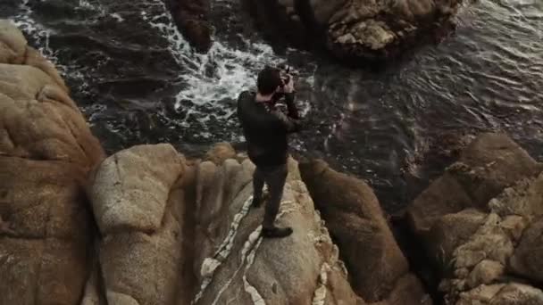 Uomo Vestito Nero Erge Una Roccia Fotografa Mare Con Una — Video Stock