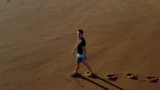 Мужчина Идет Пляжу Волны Омывают Ноги Стрельба Сверху Помощью Беспилотника — стоковое видео