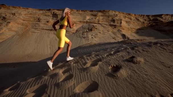 Ένα Αθλητικό Ξανθό Κορίτσι Τρέχει Στην Παραλία — Αρχείο Βίντεο