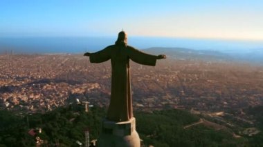 Tibidabo Dağı 'ndaki İsa heykeli ve Akdeniz ve dağlardaki Barcelona manzarası üzerine bir İHA' dan yakın çekim. Heykelin etrafında ateş ediyorlar.
