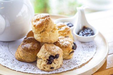 İngiliz kahvaltısı ve çay molası, çörekler bir fincan çay ile ahşap tablo.