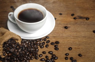 Duman ve fasulye ahşap masa var kahve bir fincan. Espresso diyet planı için kullanabilirsiniz.