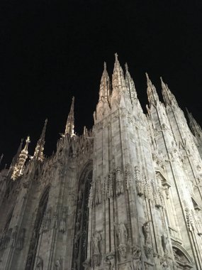 heykeller ve kemerli pencereler ile eski Gotik kilise duvarlarının gece alttan görünüm