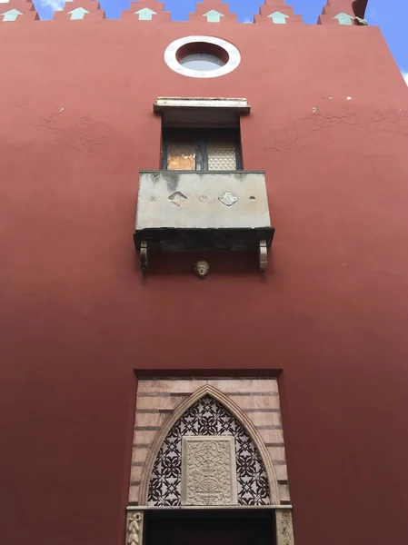 Gündüz kırmızı duvar desenli giriş, balkon ve yuvarlak pencere görünümünü