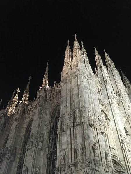 heykeller ve kemerli pencereler ile eski Gotik kilise duvarlarının gece alttan görünüm