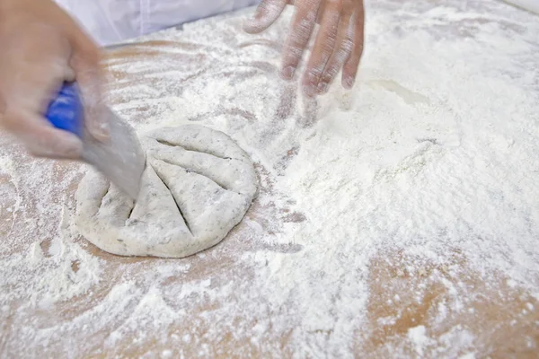 Baker molding wholemeal flour breads for baking. Sao Paulo city, Brazil