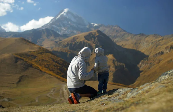 Niño con padre mirando increíbles montañas nevadas glaciares y colinas marrones en otoño. Viajar con niños — Foto de Stock