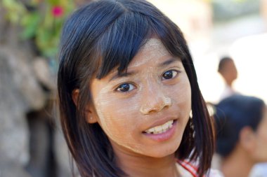 Bagan, Burma Myanmar - 3 Aralık 2012. Yüzünde Thanaka kozmetik olan gülümseyen Birmanyalı genç kızın portresi.