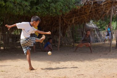 Bagan, Burma Myanmar - 11 Kasım 2012. Birmanyalı çocuklar küçük bir köyde futbol oynuyorlar. Genç çocuk gol atıyor.
