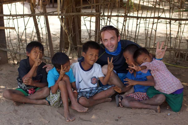Bagan, Burma Myanmar - 11 Kasım 2012. Mutlu gülümseyen Birmanyalı çocukların portresi, genç beyaz tenli kumların üzerinde oturuyor.