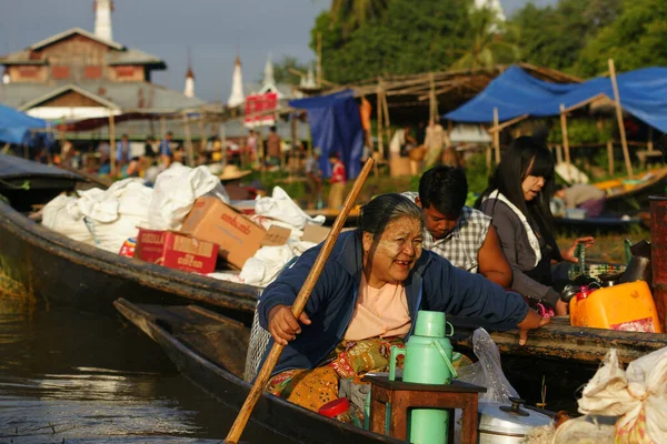 Nyaung Shwe en Inle Lake, Birmania - 4 de diciembre de 2012. Birmano sonriente mujer con thanaka en la cara sentado en barco en el lago — Foto de Stock