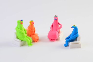 Koltuklarda oturan renkli plastik heykelcikler, psikolojik grup terapisi konsepti.