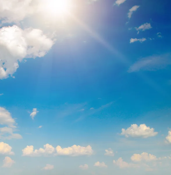 Sun on blue sky with white clouds Royalty Free Stock Images