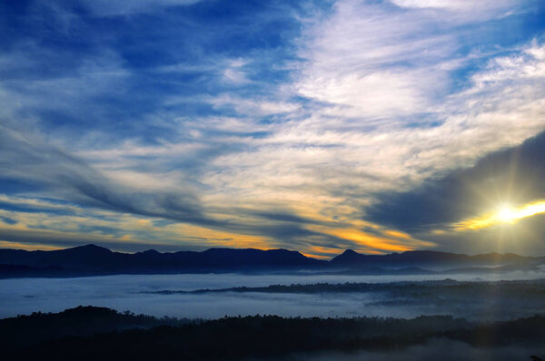 Mountain range with visible silhouettes through the morning colo