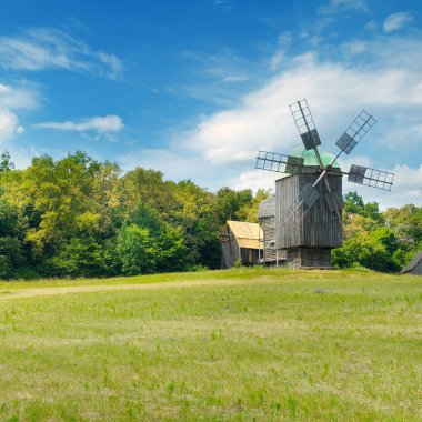 eski ahşap yel değirmenleri bir alan ve gökyüzü.
