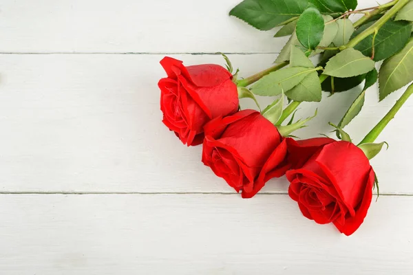 白い木製の背景に美しい赤いバラです。フラット レイアウト トップ — ストック写真