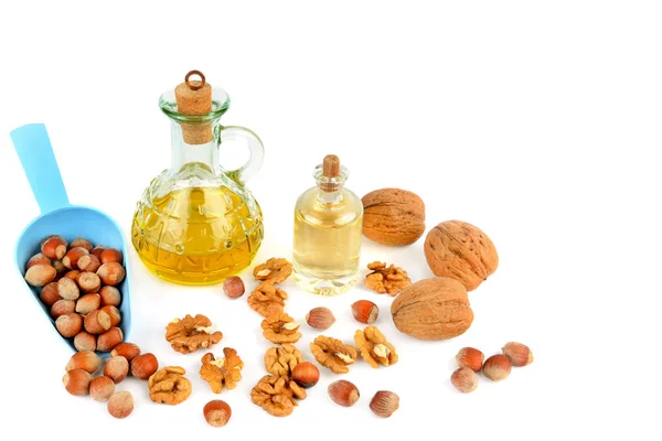 Olej z vlašských ořechů a lískových oříšků, ořechy izolovaných na bílém pozadí. — Stock fotografie