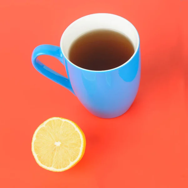 Синяя чашка с чаем на красном фоне. Flat lay, top view . — стоковое фото