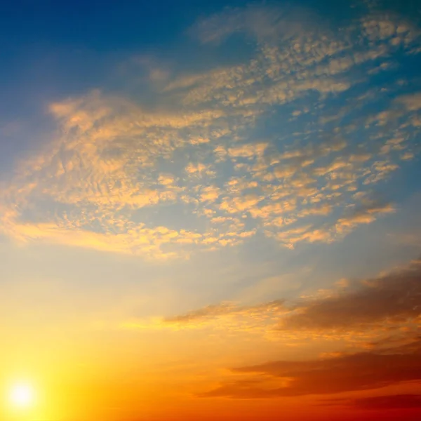 Bewolkte hemel en felle zon stijgen boven de horizon. — Stockfoto