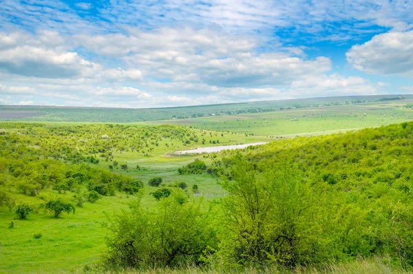 Campo verde y cielo azul. Pintorescas colinas formadas por un antiguo río — Foto de Stock