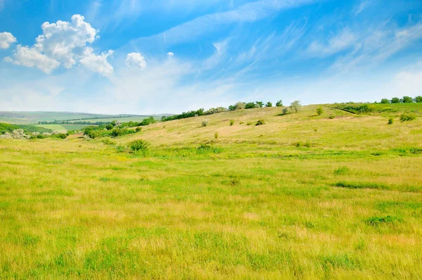 Paisaje con campo montañoso y cielo azul . — Foto de Stock