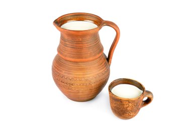 Clay jug and mug with milk isolated on white background.