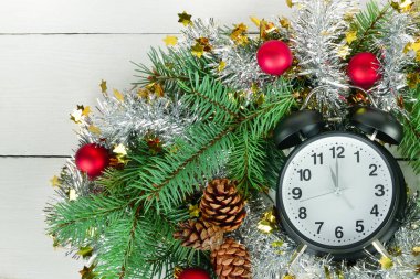 Çalar saat ve beyaz bir ahşap üzerinde Noel ağacı süslemeleri.
